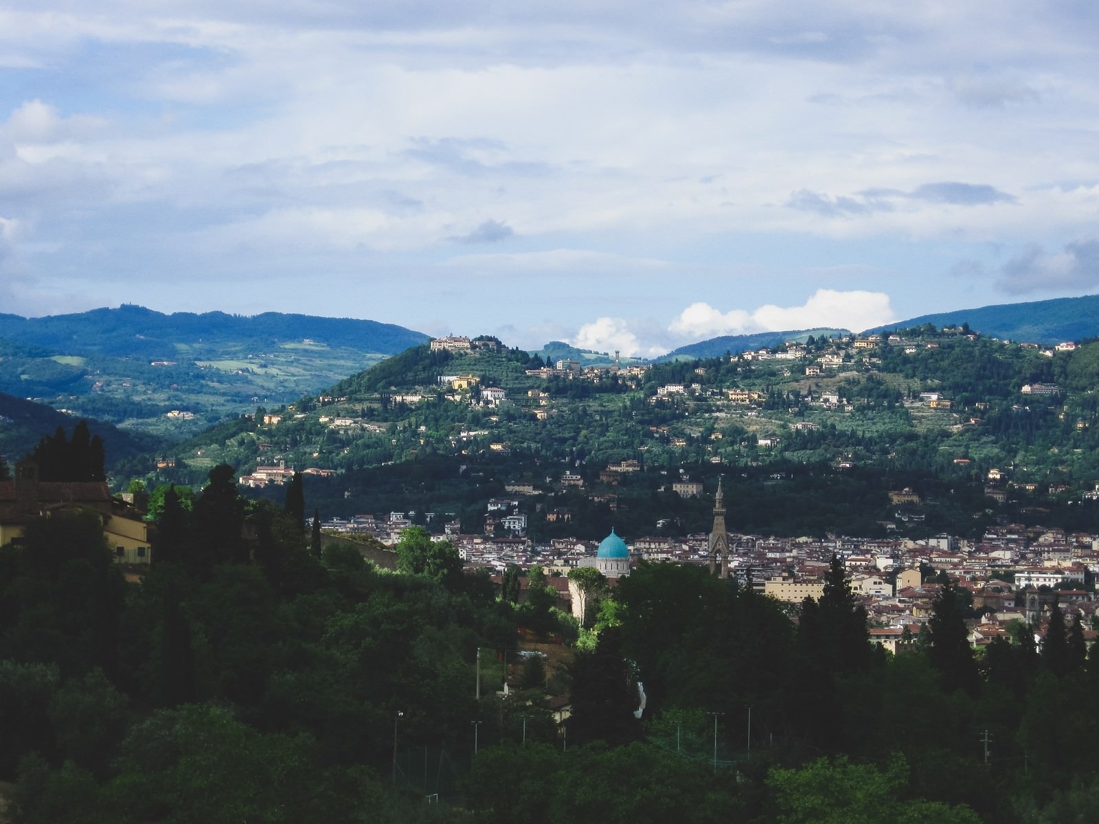 緑の丘陵に囲まれたフィレンツェの美しい街並み