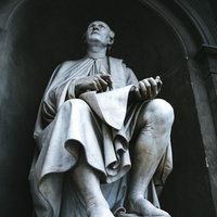 フィレンツェのアーチ状建築に設置された白い石像の写真