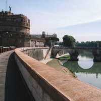 ローマのサンタンジェロ城に続く道と川に架かる橋の写真