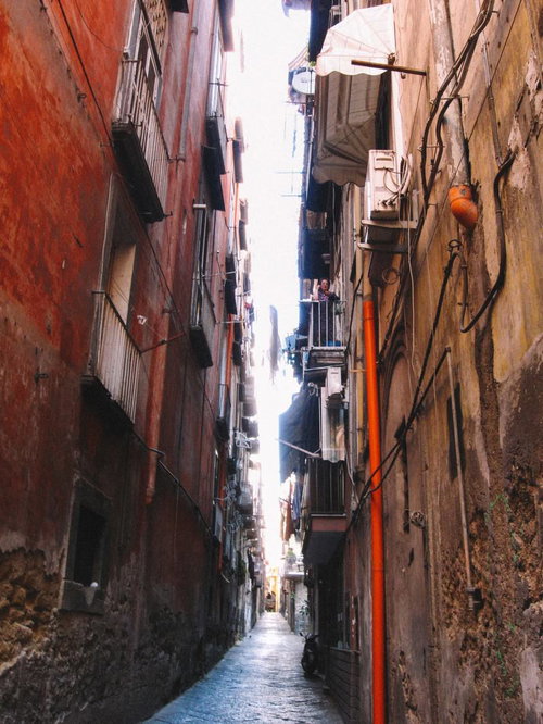 イタリアの古いアパートに挟まれた路地裏の石畳の道