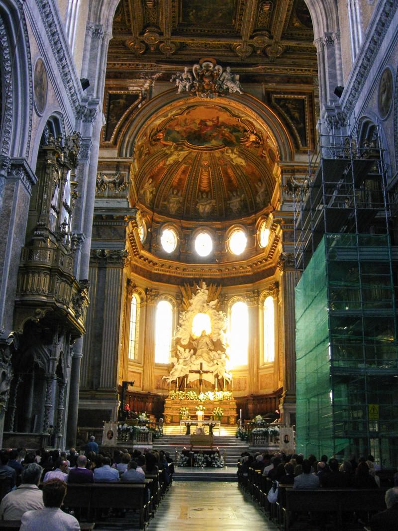イタリアの大聖堂内部で祈りを捧げる多くの参拝者と天井画