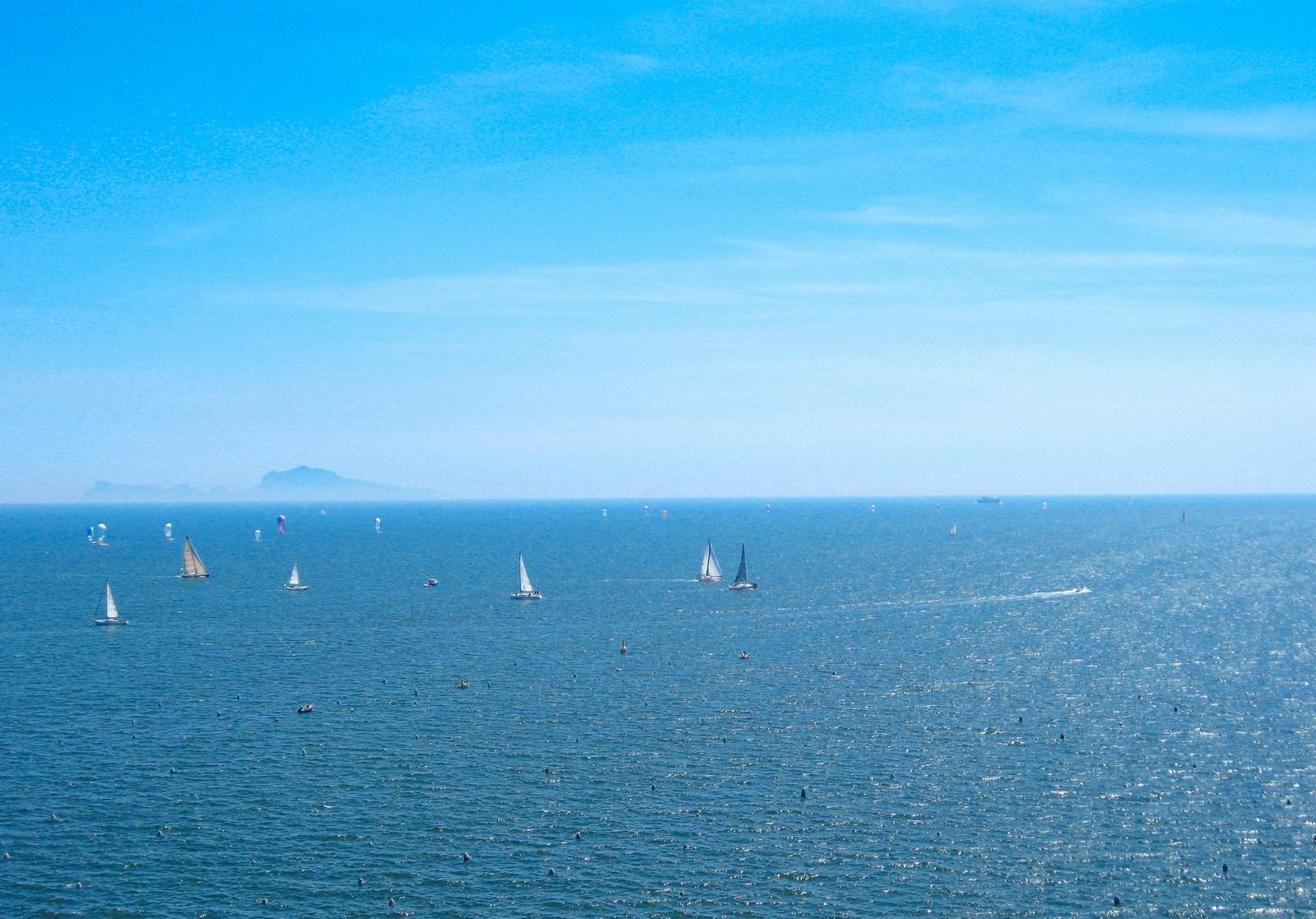 ナポリの青い海と空、白いヨットが浮かぶ紺碧の海面