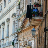 オルヴィエートの出窓に並ぶ花と洗濯物、ヨーロッパの日常（イタリア）の写真