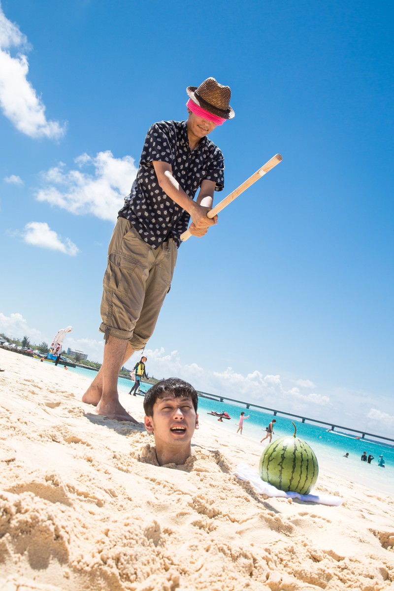 砂浜でスイカ割りをする男性と子ども［モデル：大川竜弥］