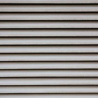 影が落ちた白い横板が並ぶ古いシャッターのテクスチャーの写真