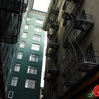非常階段が取り付けられた都市の路地裏のビルの写真
