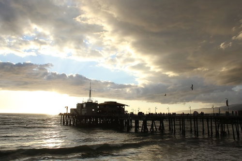 夕暮れの海に建つ木製桟橋と波