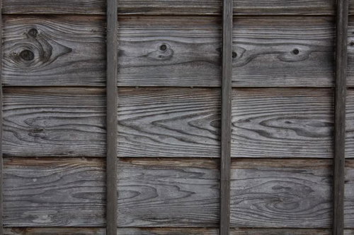 古民家の木造外壁に並ぶ縦板の木目と風合い