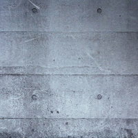 継ぎ目と丸いくぼみがあるコンクリート壁のテクスチャーの写真