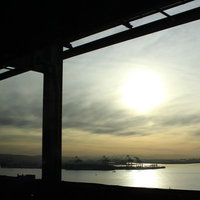 夕暮れの水辺に浮かぶ工業地帯のシルエットの写真