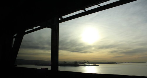 夕暮れの水辺に浮かぶ工業地帯のシルエット