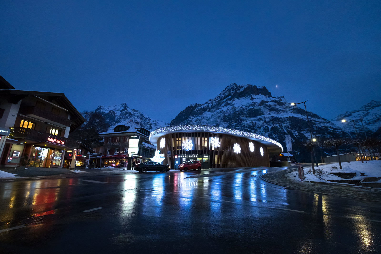 夜のグリンデルワルトで雪山を背景にライトアップされた街並み