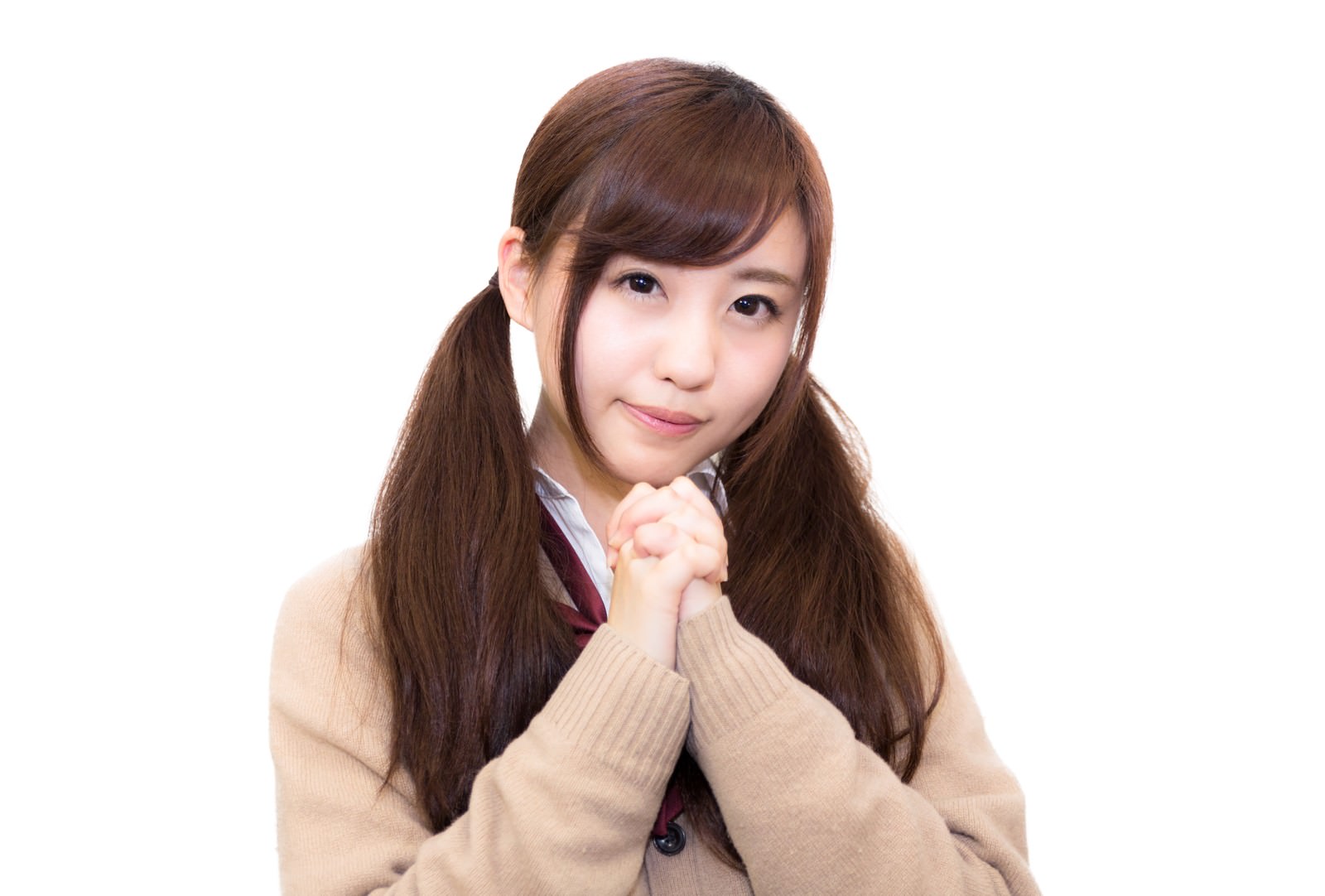 両手を合わせて祈る女子高生。カーディガン姿で真摯な表情［モデル：河村友歌］