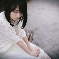 隣に座る幸せそうなカップルを見つめる失恋女子の写真