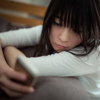 彼からの返信を待ちながらスマホを確認する失恋女子の写真