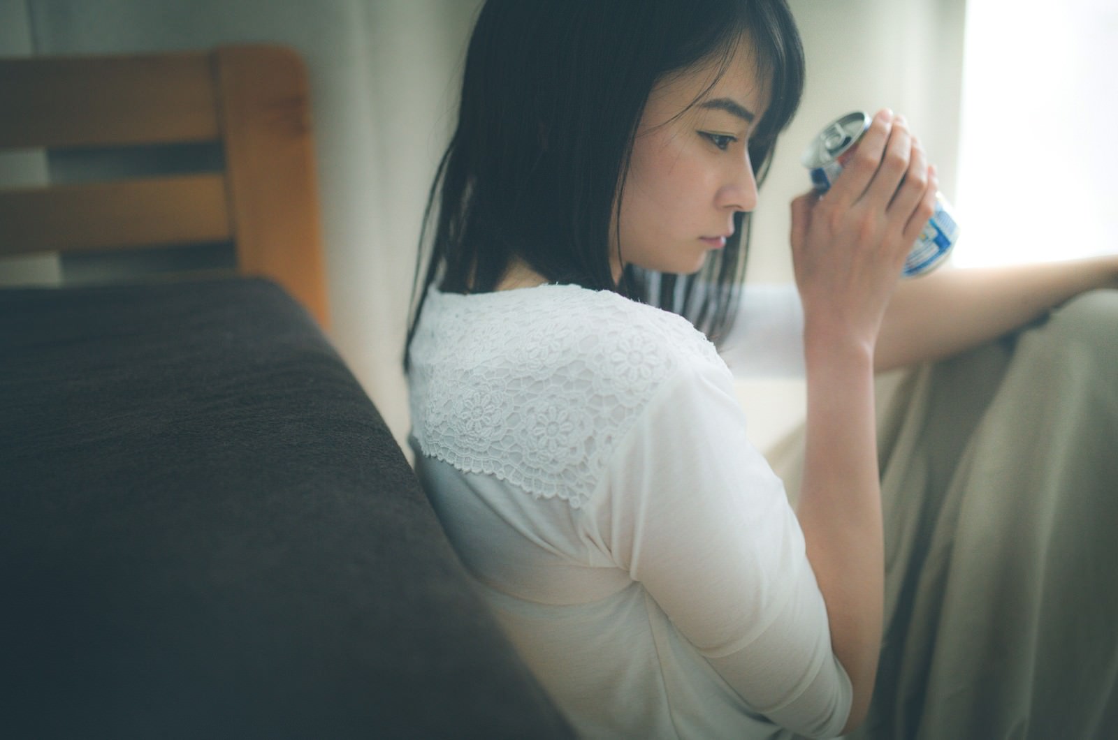 窓辺でチューハイを片手に持つ失恋した女性［モデル：たけべともこ］