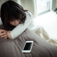 クリスマスイヴにフラれたサイレントガール、スマホを前に沈むの写真