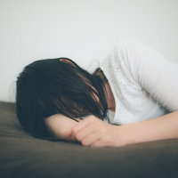 ひとり腕枕で寂しさを紛らわす失恋女子の傷心の写真
