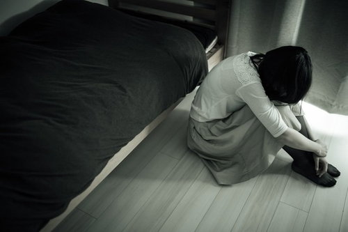 ワンルームで体育座りする憂鬱な朝の失恋女子