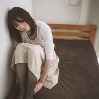 ベッドの上で膝を抱えて下を向く失恋女子の心理描写の写真