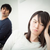 なんでこんな男好きになっちゃったんだろう...と悩む女性と背後の男性の写真