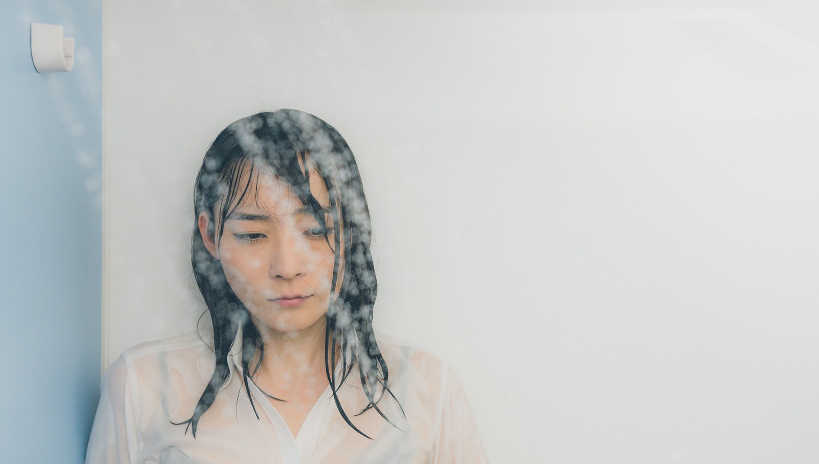 シャワーを浴びながら涙を流す女性の横顔［モデル：たけべともこ］