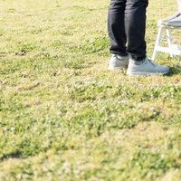身長差カップルが脚立を使う屋外での一枚、芝生の上での写真