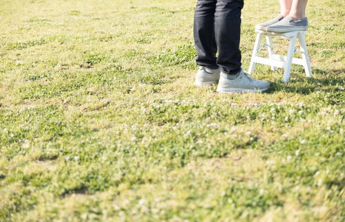 身長差カップルが脚立を使う屋外での一枚、芝生の上で