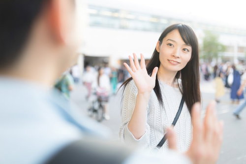 彼女と駅前で手を振って待ち合わせ、再会を喜ぶ