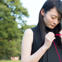 ちぎれた赤い糸を結び直す女性の手元 失恋からの恋愛回復の写真