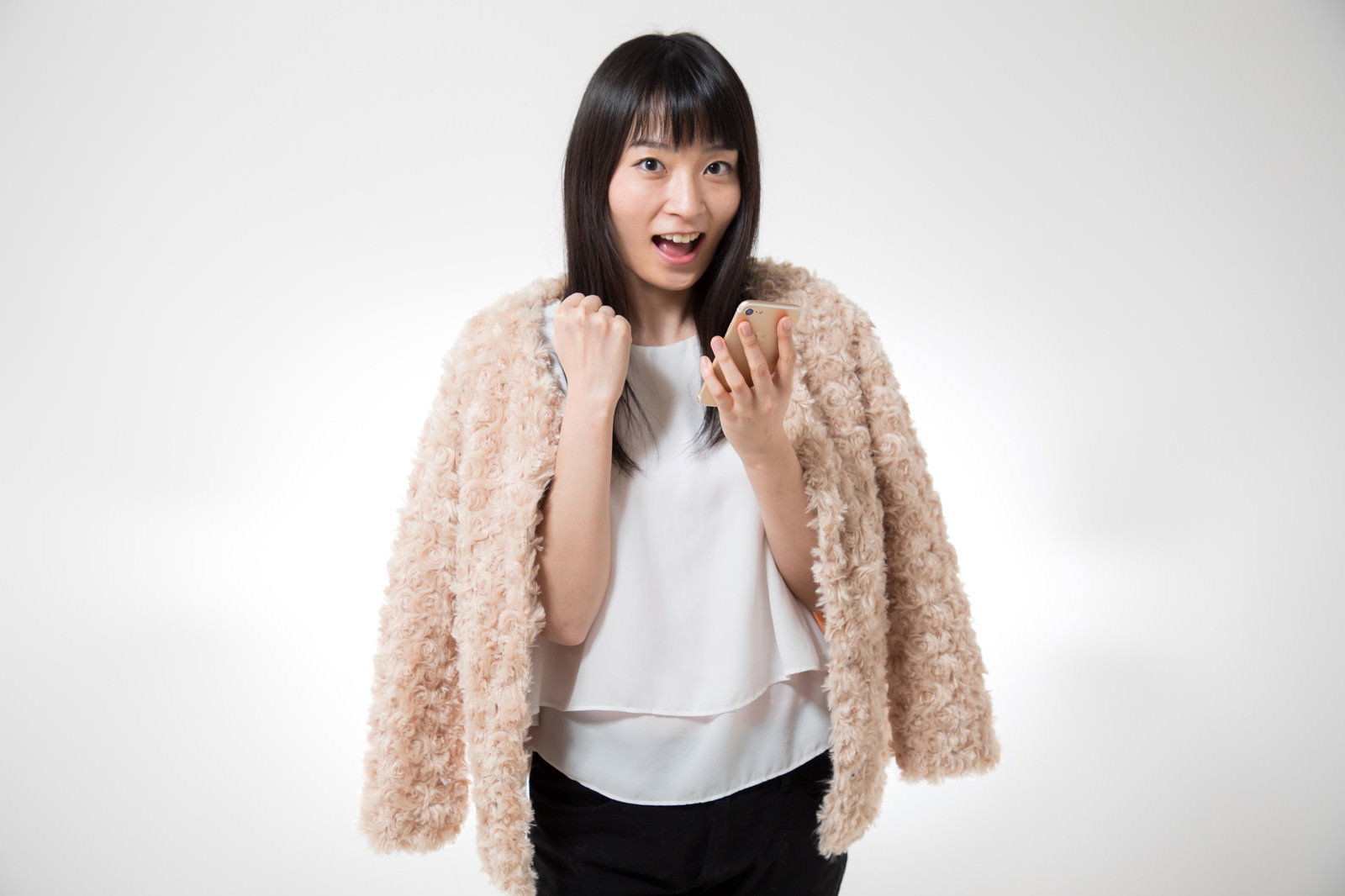 当選メールを見てガッツポーズして喜ぶ女性［モデル：たけべともこ］