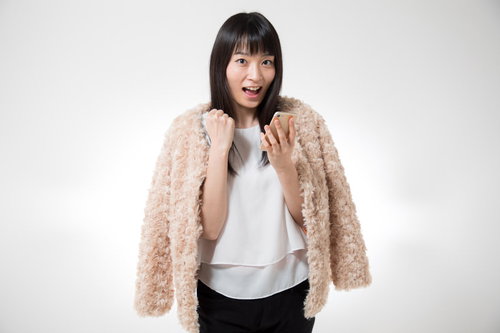 当選メールが来てガッツポーズする喜ぶ女性