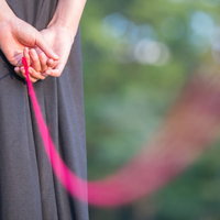 赤い糸で繋がれた恋人との関係を表現した手つながりの写真