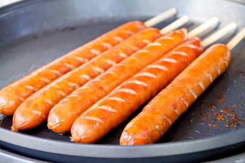 炭火の上で焼き色がつくバーベキューのフランクフルト