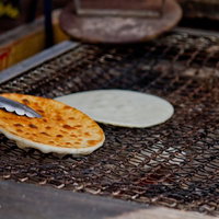 炭火の熱で焼き色がつく網の上のせんべいの写真