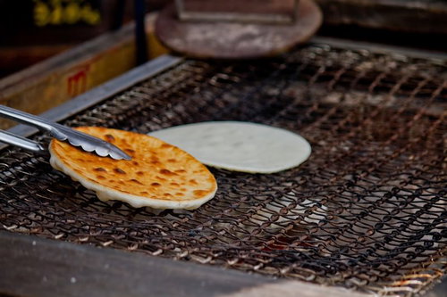 炭火の熱で焼き色がつく網の上のせんべい