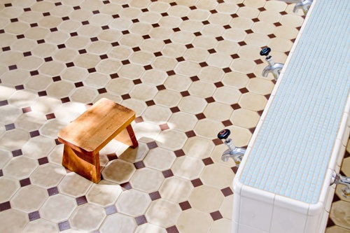 窓から光がさす明るいタイル壁の銭湯の内部