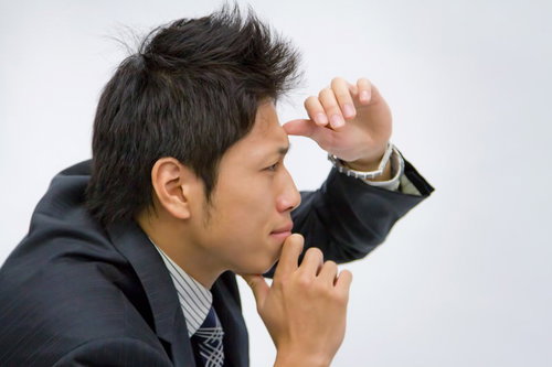 腕を組んで遠くを見定める男性のポートレート