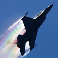 虹を背景に滑走路に駐機する米軍F-16戦闘機の写真