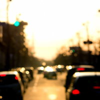 オレンジの夕焼けの下で車が混雑する道路の写真