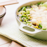 ネギたっぷりの鍋とスープ、白ネギと青ネギが彩る和食の食卓の写真