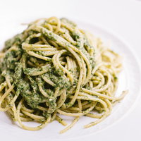 セリが爽やかに香るジェノベーゼ風パスタ、白い皿に盛られたスパゲティの写真