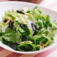 ごま油風味のグリーンサラダ、白い皿に盛り付けた新鮮野菜の写真