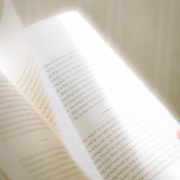 洋書のページを指でめくる手元、英語学習の教材の写真