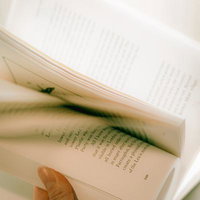 洋書のページをめくる手元のクローズアップの写真