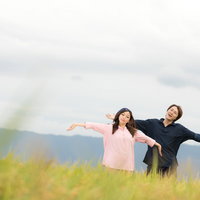 広大な田園と黄金色の稲穂に囲まれて両手を広げる移住組（福岡県大刀洗町）の写真