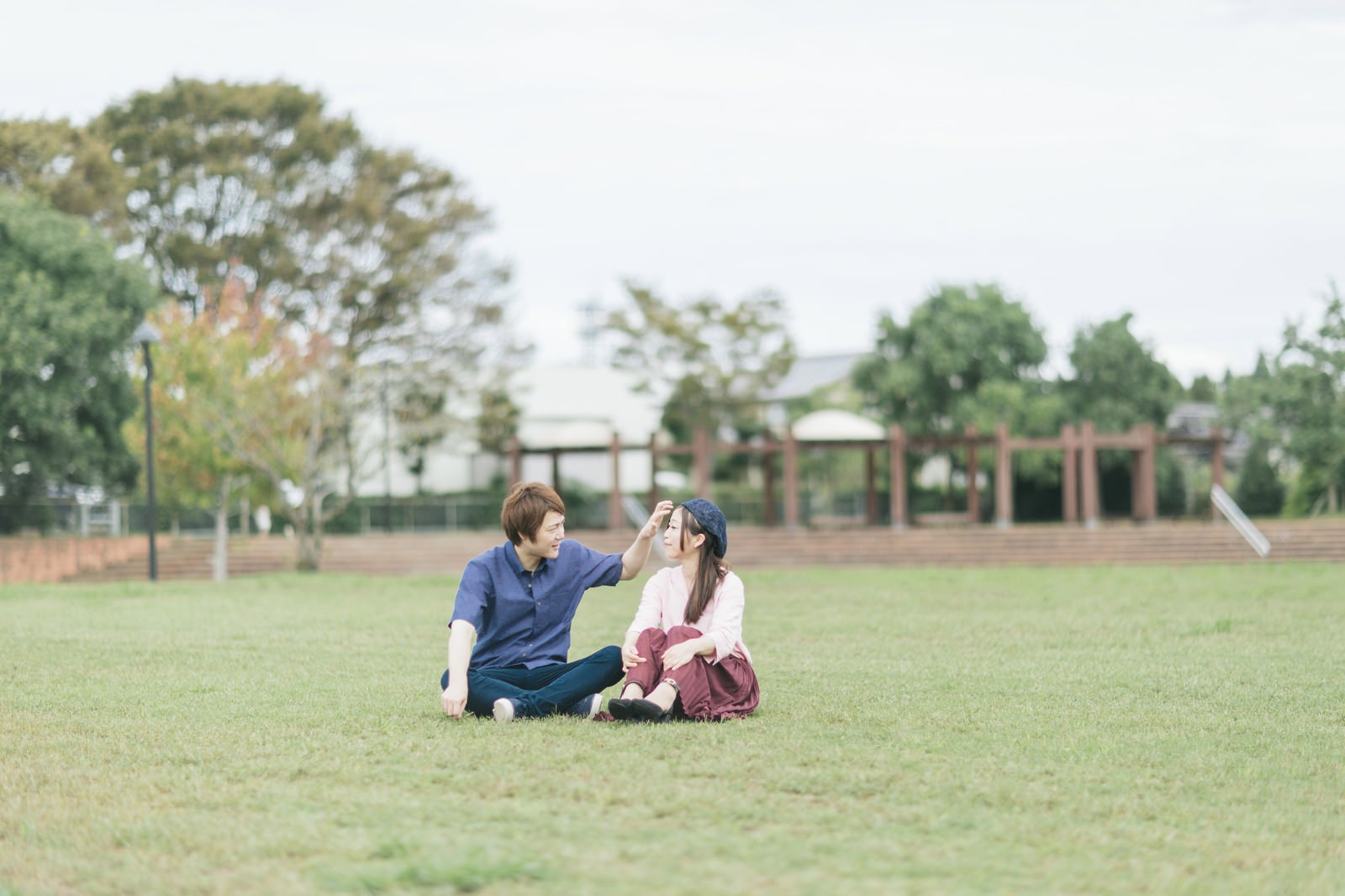 大刀洗公園の芝生で向き合って座る夫婦［モデル：五十嵐夫妻］