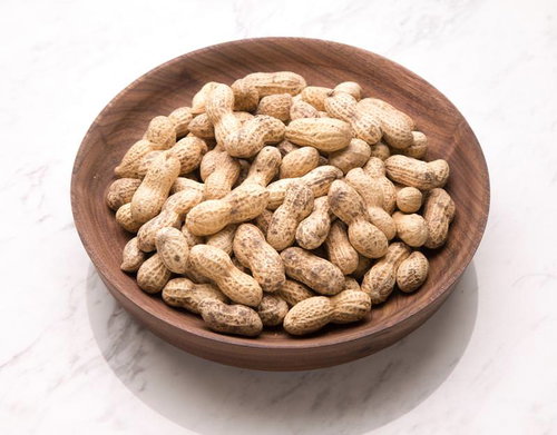 木製のお盆に盛られた殻付きの落花生とピーナッツ