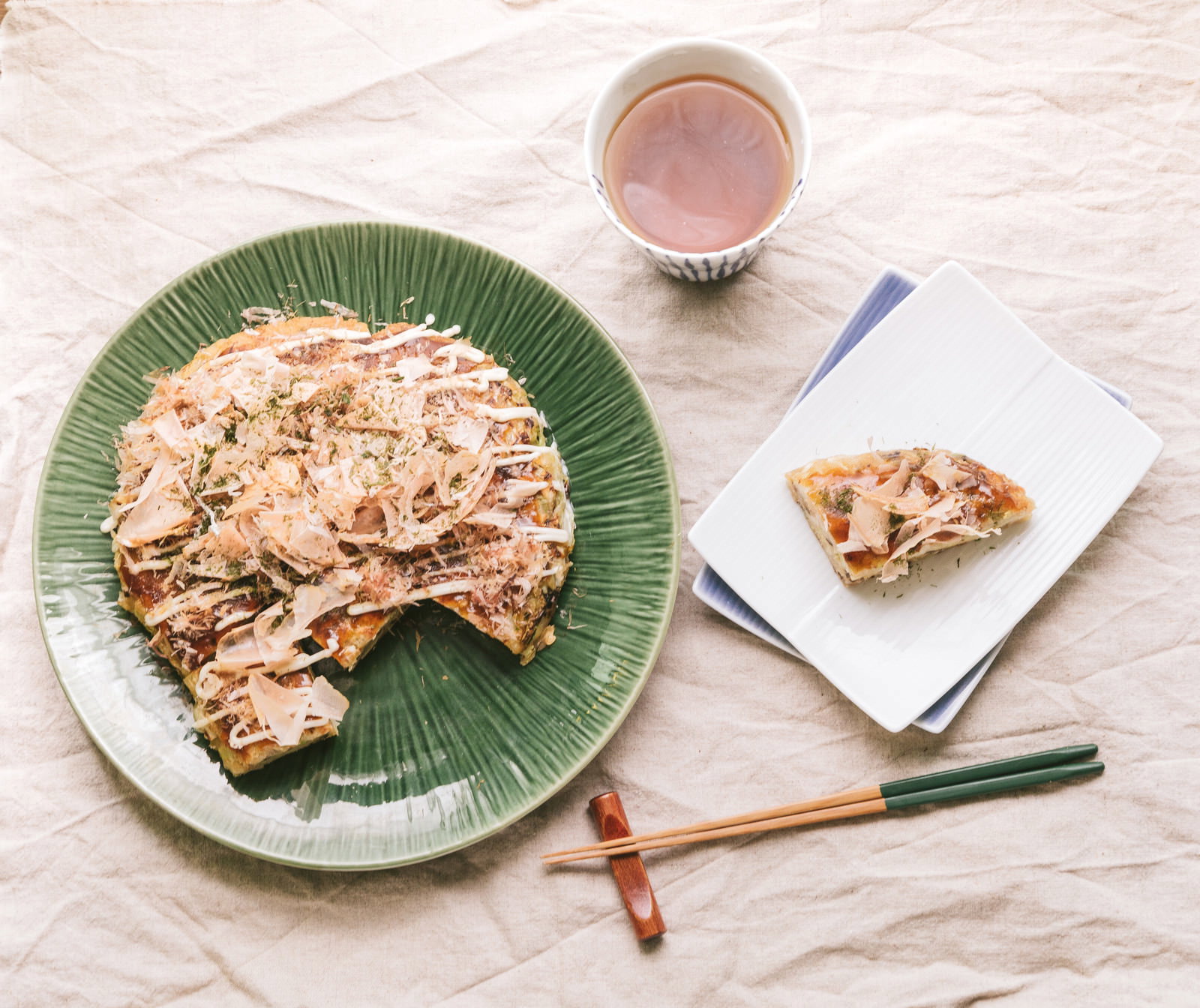 お好み焼きを盛り付けた食卓、桜エビと青のりがトッピングされた和食
