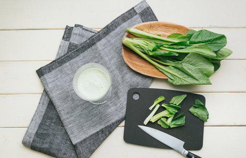 黒いまな板で小松菜をカットしてスムージー作り